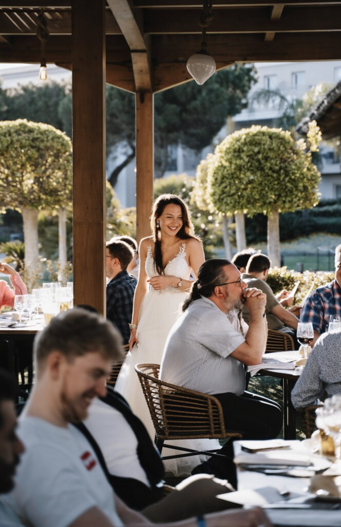 Authentische Hochzeitsreportage in Sevilla: Braut unterhält sich mit Gästen bei einer Outdoor-Hochzeit unter spanischer Sonne